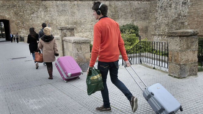 Viajeros con maletas, por las inmediaciones de las Puertas de Tierra.