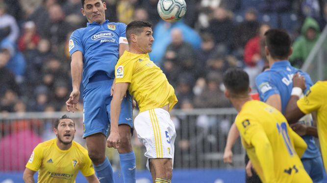 Garrido intenta cabecear el balón en pugna con Juanma, jugador del Fuenlabrada.