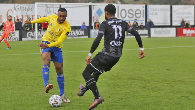 Akapo, debutante en el Cádiz, golpea el balón delante de Miki durante el partido contra el Lealtad.