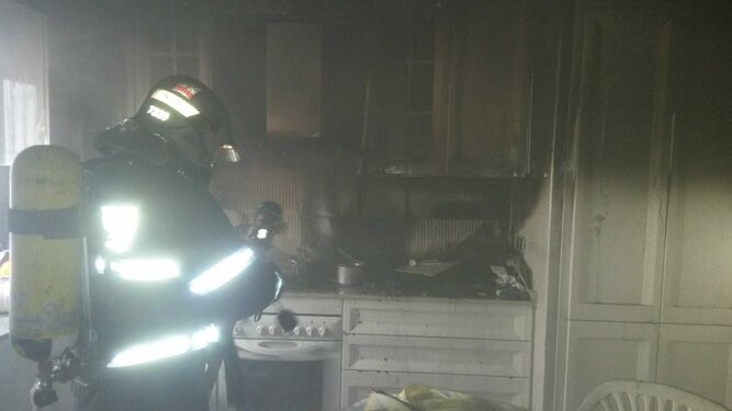 Un bombero en el interior de la cocina en la que se ha producido el incendio.