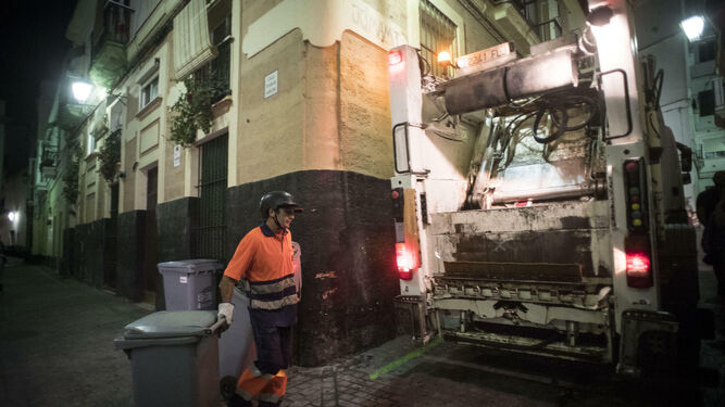 Un operario recoge los contenedores de basura en el barrio de Santa María.