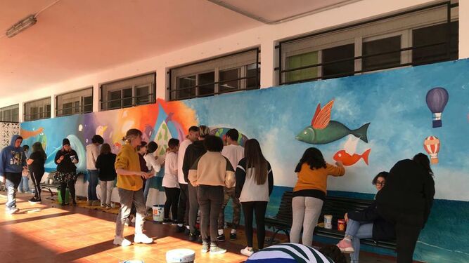 Los jóvenes durante la elaboración del mural en una de las paredes del centro educativo.