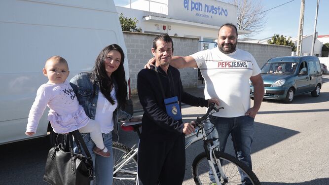 Fernando Manuel, con su bicicleta nueva, junto a Carlos y su familia, ante El Pan Nuestro.