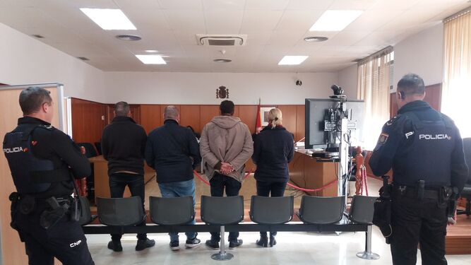 Los cuatro procesados por la brutal agresión, de espaldas, durante la celebración del juicio.
