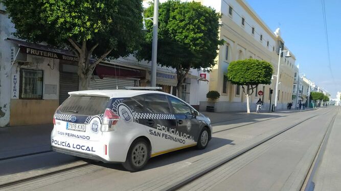 Un coche de la Policía Local por la calle Real.