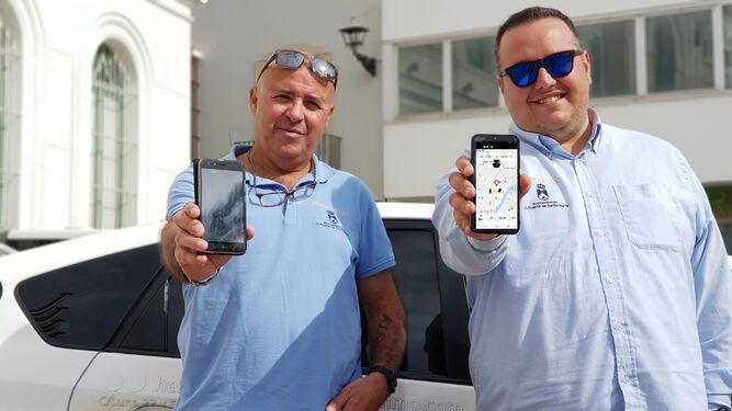 Dos de los taxistas mostrando la aplicación en sus teléfonos.
