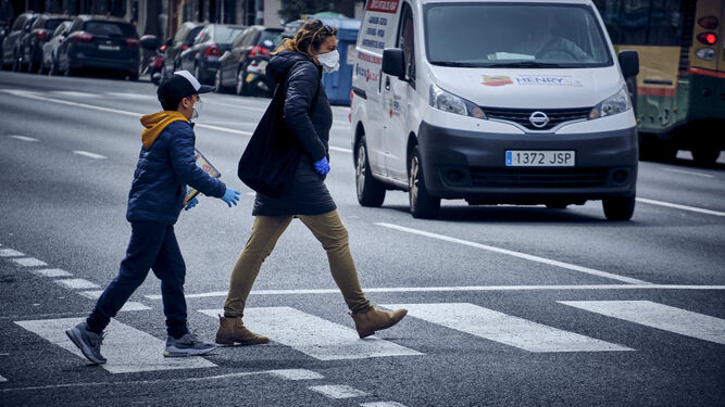 Una mujer y un ni&ntilde;o cruzan el paso de peatones frente al Hospital Puerta del Mar