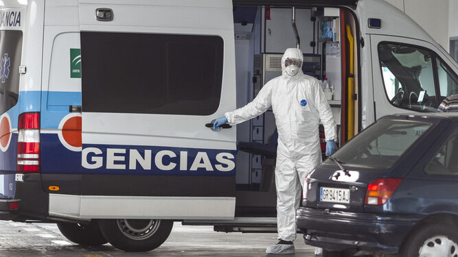 Un sanitario, protegido, sale de una ambulancia en Granada.