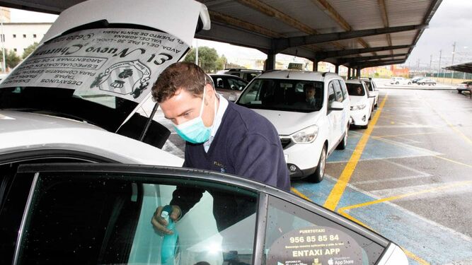Un taxista desinfectado su vehículo.