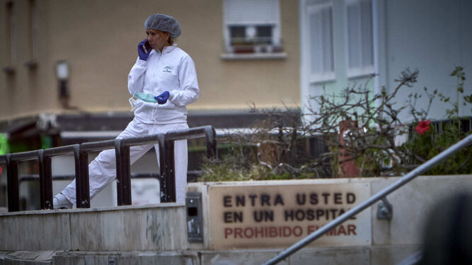 Una empleada del hospital 'Puerta del Mar' habla por su m&oacute;vil en el exterior