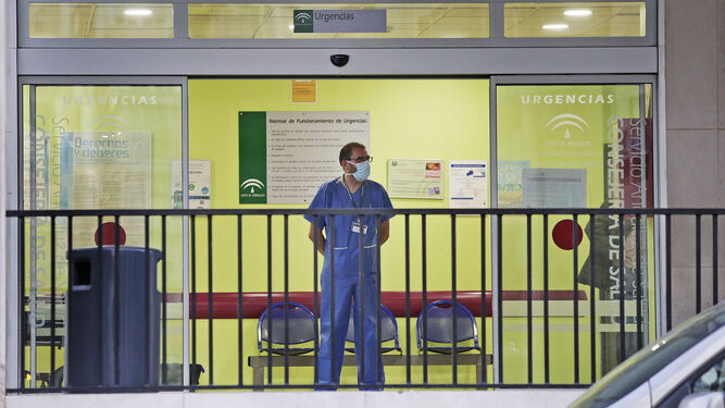 Un profesional sanitario con mascarilla en la entrada de Urgencias del Puerta del Mar.
