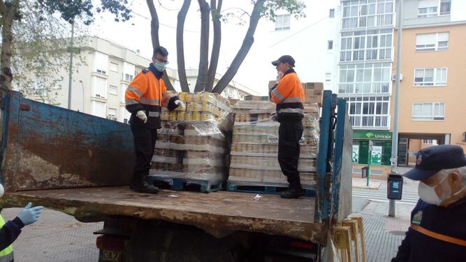Miembros de Protección Civil descarga el camión del Banco de Alimentos de Cádiz