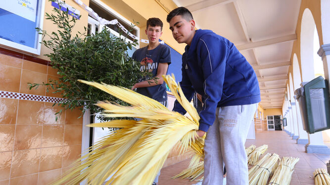 Dos jóvenes preparan las palmas para la procesión de La Borriquita, en una imagen del pasado año.