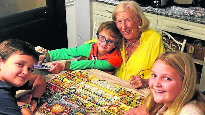 Helena Gómez, con 96 años, haciendo un puzzle  con su nietos y bisnietos,  durante su confinamiento en las afueras de Buenos Aires, Argentina