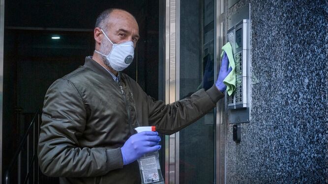 Manuel Suárez, el Lolo, estos días, sacándole brillo y desinfectando el portero automático para evitar contagios.