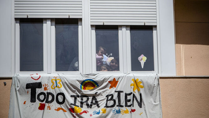 Varios niños asomados en una ventana.