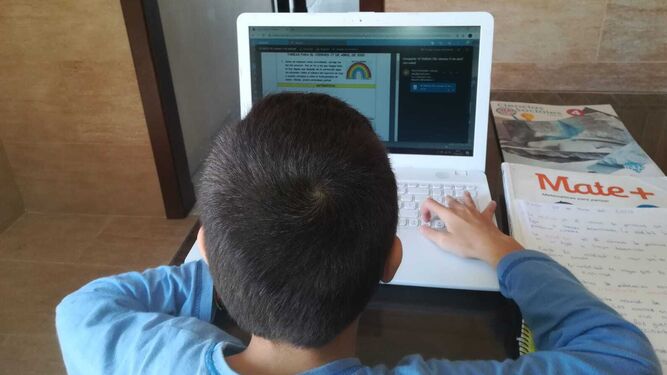 Un alumno utiliza un ordenador para seguir las clases desde casa