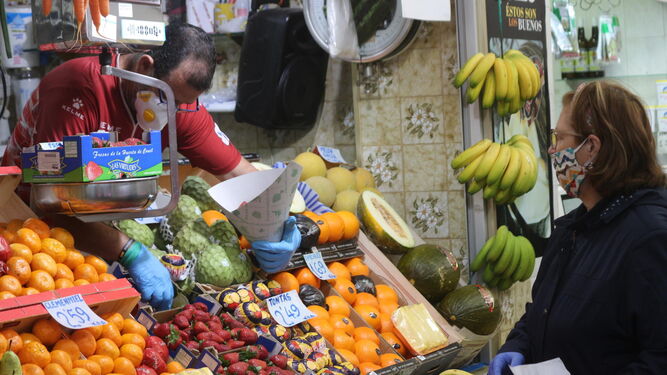 Una clienta compra fruta en uno de los puestos del Mercado de Abastos