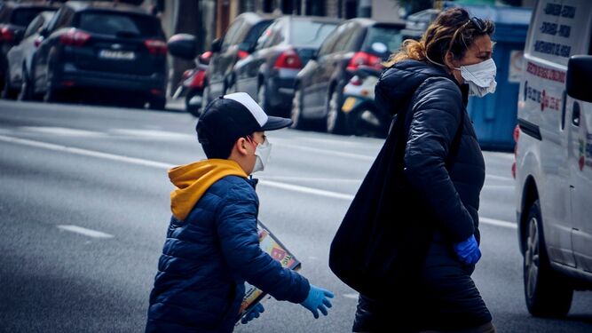 Un niño con mascarilla por la calle.