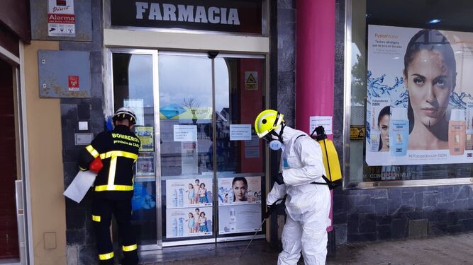 Bomberos desinfectando el acceso a una farmacia en Sanlúcar.