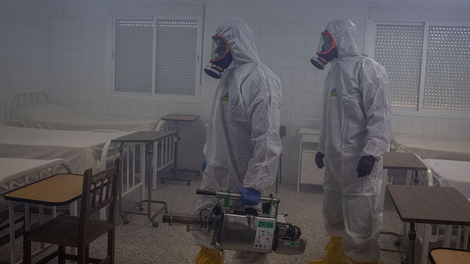 Dos miembros del equipo del CEFOT-2 de Camposoto, trabajando con el termonebulizador para erradicar el virus.