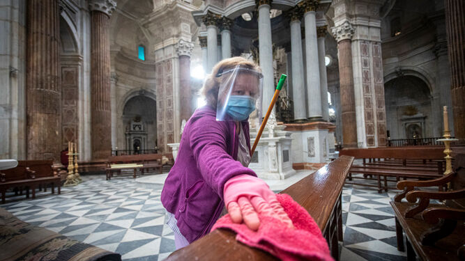 Una operaria de la Catedral limpia una barandilla siguiendo el protocolo para el coronavirus