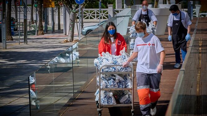 Voluntarios de Cruz Roja y personal de Parador Hotel Atlántico,  cargados con los menús