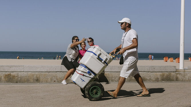 Un vendedor de latas se dirige a la playa por el Paseo Marítimo.