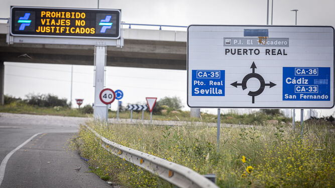 carteles en dirección a Cádiz y el aviso de la prohibición de viajes.
