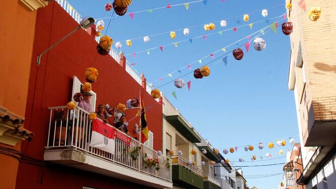 Vecinos de la calle Revolera, rodeados de farolillos en la semana de la Feria portuense.