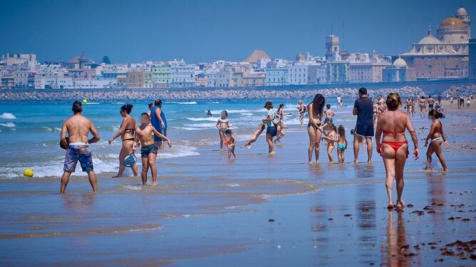 Cientos de personas disfrutan de la playa de C&aacute;diz este viernes pese a las restricciones sanitarias.
