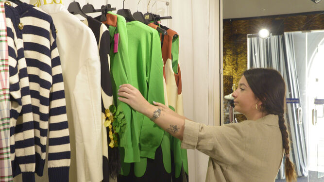 Una mujer prepara una tienda de ropa