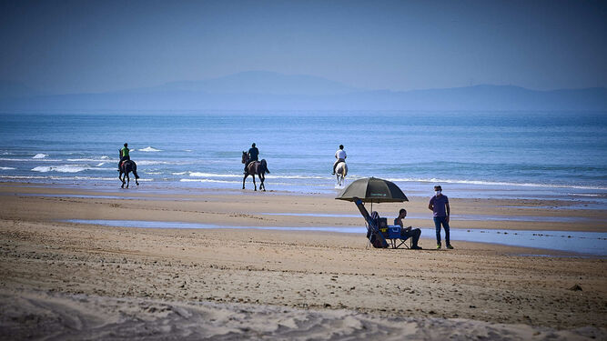 Playas de Conil. Paseos a caballo y usuarios en la orilla de la Fontanilla.