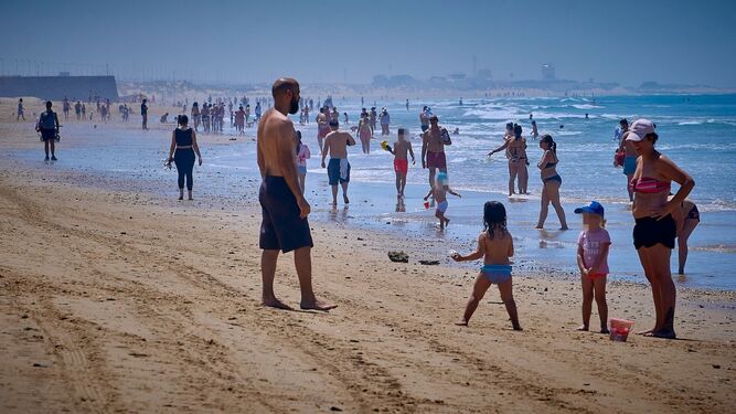 Padres e hijos toman el sol en la playa Victoria este viernes.