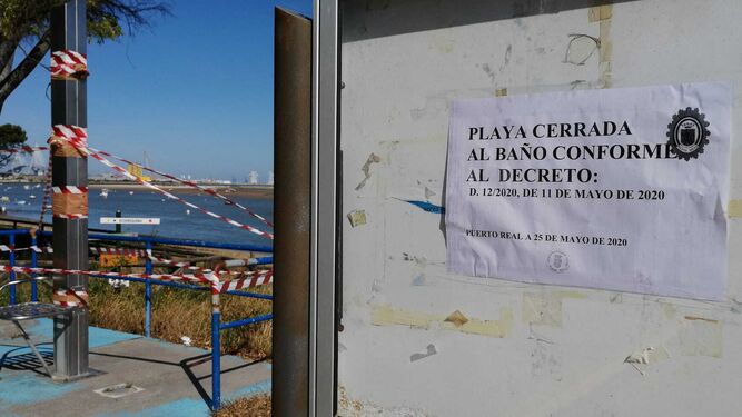 Un cartel advierte de la prohibición del baño en una playa de Puerto Real