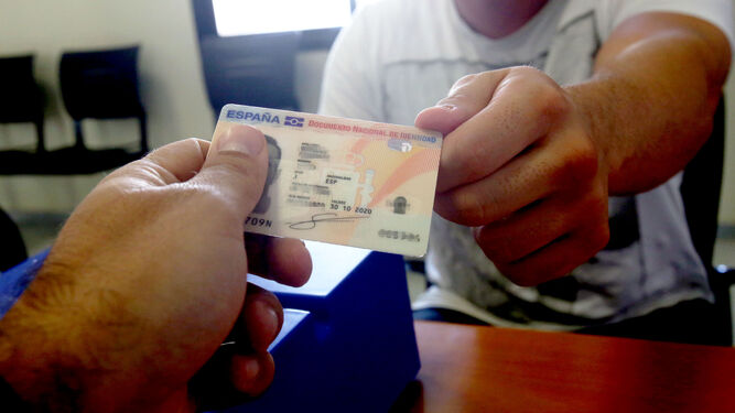 Un funcionario entrega el DNI  a un ciudadano, en una imagen de archivo.