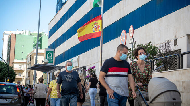 Varias personas pasean junto al hospital Puerta del Mar de Cádiz.