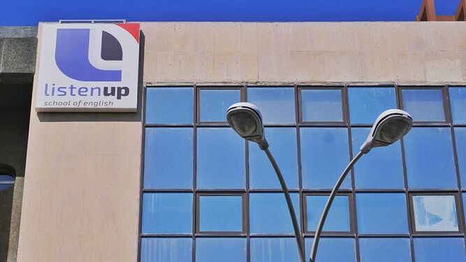 Logotipo de la academia ListenUp en un edificio de oficinas de la avenida Andalucía.