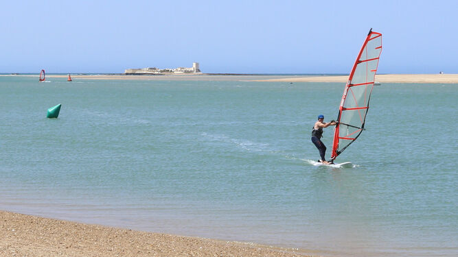 Una persona durante la práctica de windsurf en la mañana de hoy en la playa de Sancti Petri.