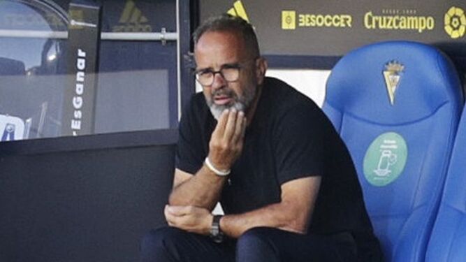 El entrenador del Cádiz se lleva la mano a la barbilla en su lugar en el banquillo.