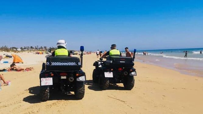 Dos agentes en la playa de El Palmar.