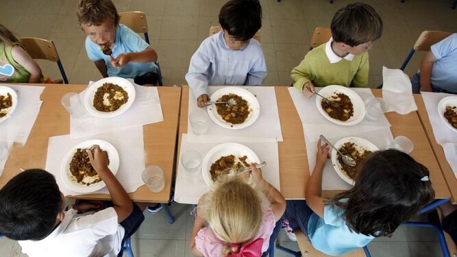 Alumnos almorzando en un comedor escolar.