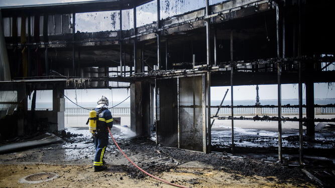Un bombero termina de extinguir el incendio de la pérgola de Santa Bárbara.