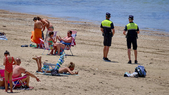 Dos agentes vigilan la playa de Cádiz el primer día de su apertura al baño.