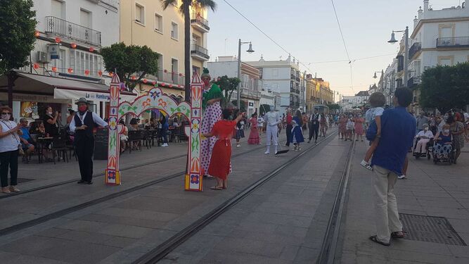 El pasacalles con zancudos y personajes de la Feria, por la calle Real.