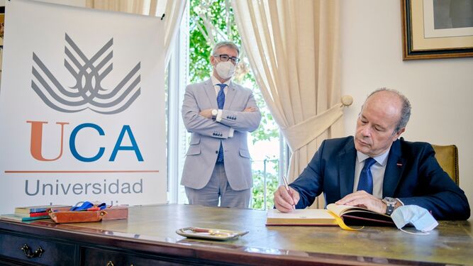 Juan Carlos Campo firma en el Libro de Honor de la UCA en presencia del rector, Francisco Piniella.
