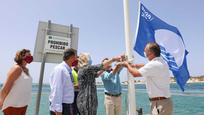 Momento del izado de la Bandera Azul en el puerto de Sancti Petri por parte de los responsables de la Junta y el Consistorio.
