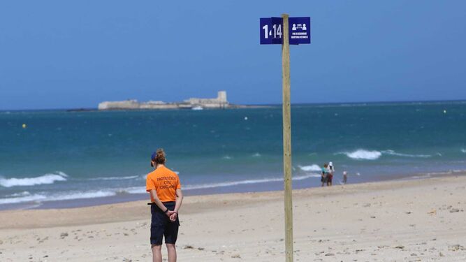 Una voluntaria de Protección Civil en la playa de La Barrosa, en una imagen de hace unos días.