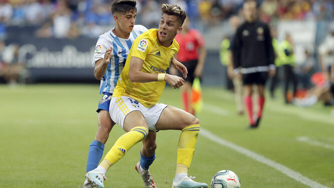 Iván Alejo protege el esférico ante el acoso de un jugador del Málaga.