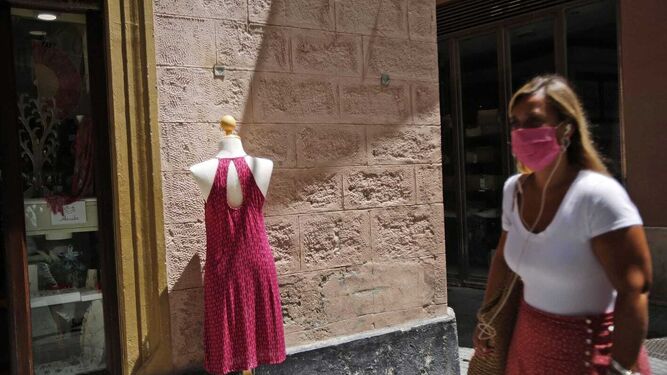 Una mujer con su mascarilla paseando por Cádiz.